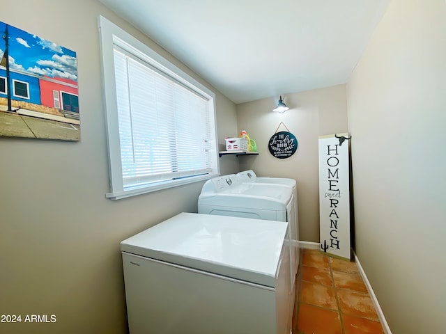 clothes washing area with washing machine and dryer and light tile patterned floors