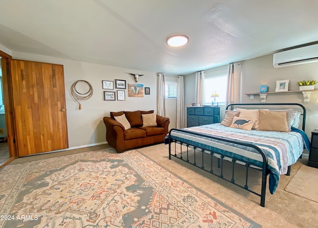 carpeted bedroom featuring a wall unit AC