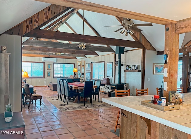 tiled dining room with vaulted ceiling with beams, a wall mounted air conditioner, and ceiling fan