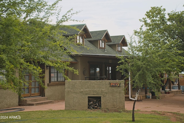 view of front facade featuring stucco siding, roof with shingles, and entry steps