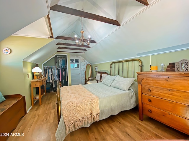 bedroom with lofted ceiling with beams, a closet, a notable chandelier, and wood finished floors