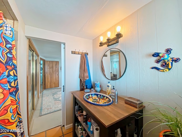 bathroom featuring vanity, wood walls, and tile patterned floors