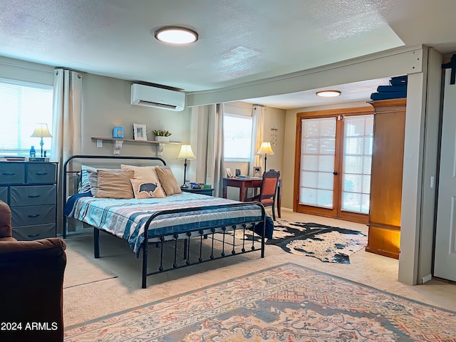 carpeted bedroom with a textured ceiling, french doors, and a wall mounted AC