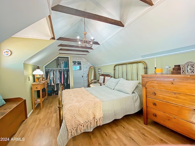 bedroom featuring a chandelier, light wood-type flooring, a closet, and lofted ceiling