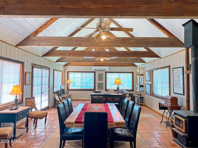 tiled dining area with lofted ceiling with beams, a wall mounted AC, ceiling fan, and a wood stove