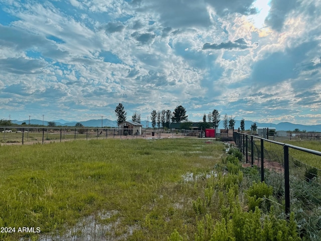 view of yard featuring a mountain view, a rural view, and fence