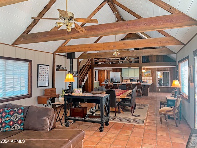 tiled living room featuring beamed ceiling, high vaulted ceiling, and ceiling fan