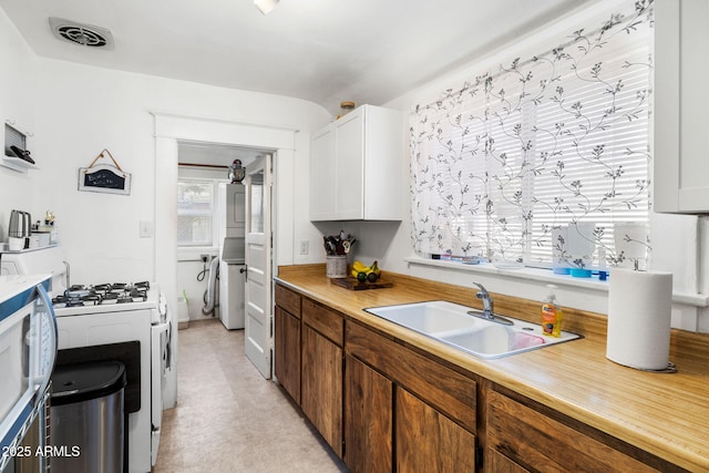 kitchen featuring light countertops, white appliances, a sink, and visible vents
