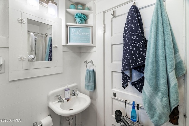bathroom with a shower with shower curtain and a sink