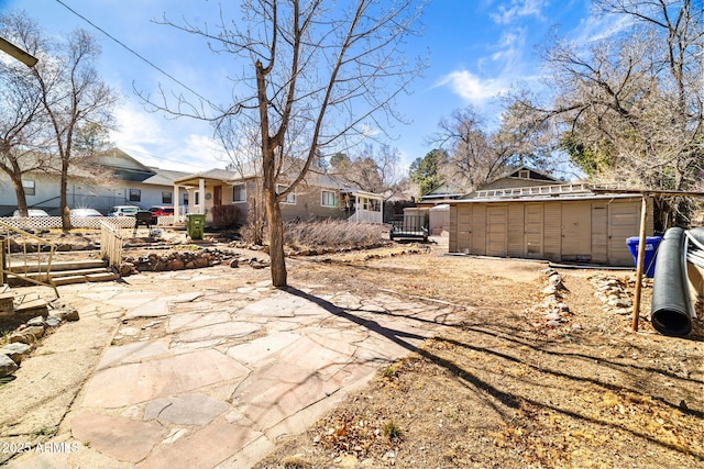 rear view of property with an outdoor structure, a residential view, fence, and a storage shed