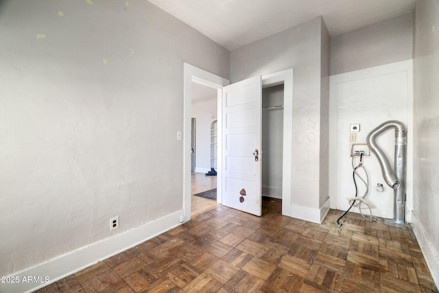 unfurnished bedroom with a closet and baseboards