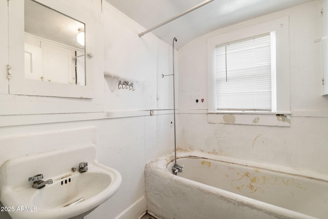 full bathroom with vaulted ceiling and a sink