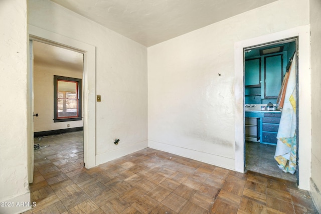 unfurnished room with baseboards