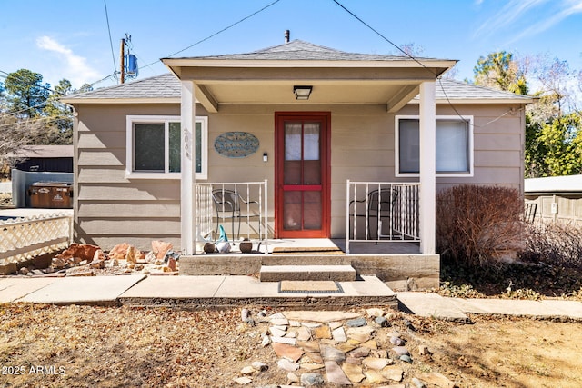 view of front of home with roof with shingles and fence