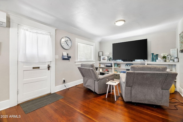 living area featuring baseboards and hardwood / wood-style floors