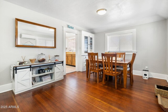 dining area featuring baseboards and dark wood-type flooring