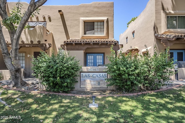 1446 E Grovers Ave Unit 13, Phoenix, AZ 85022 - pueblo revival-style home with a tile roof, stucco siding, a front yard, and french doors