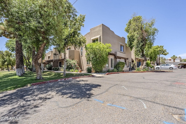 1446 E Grovers Ave Unit 13, Phoenix, AZ 85022 - view of front facade featuring uncovered parking, stucco siding, a residential view, and a front yard