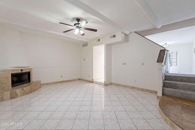 1446 E Grovers Ave Unit 13, Phoenix, AZ 85022 - unfurnished living room with beam ceiling, ceiling fan, light tile patterned floors, a tile fireplace, and stairway