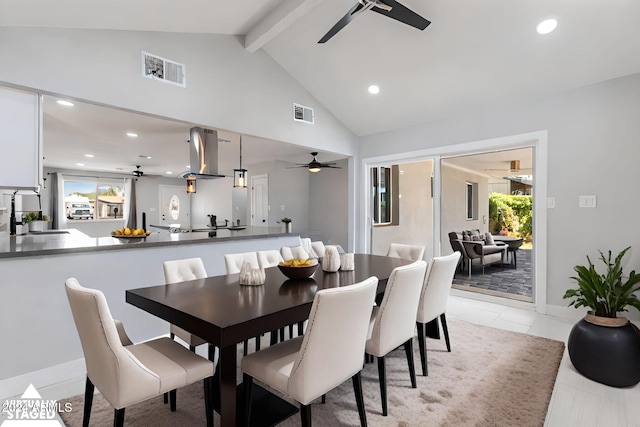 tiled dining area featuring lofted ceiling with beams, plenty of natural light, ceiling fan, and sink