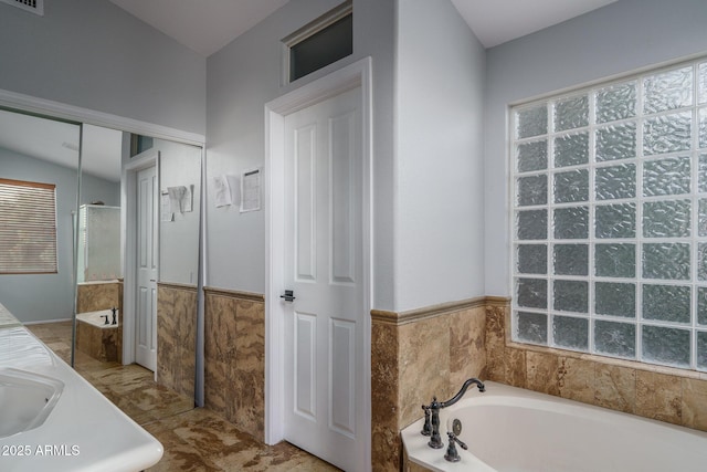 bathroom featuring a garden tub, visible vents, an enclosed shower, wainscoting, and a sink