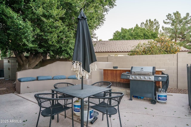 view of patio with fence, outdoor dining area, and area for grilling