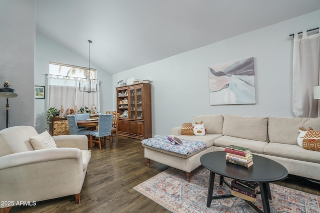 living room with high vaulted ceiling, dark wood finished floors, and a notable chandelier