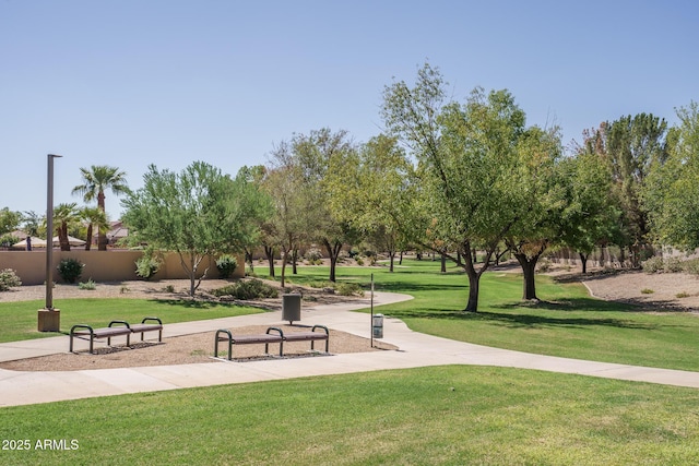 view of community with a lawn and fence