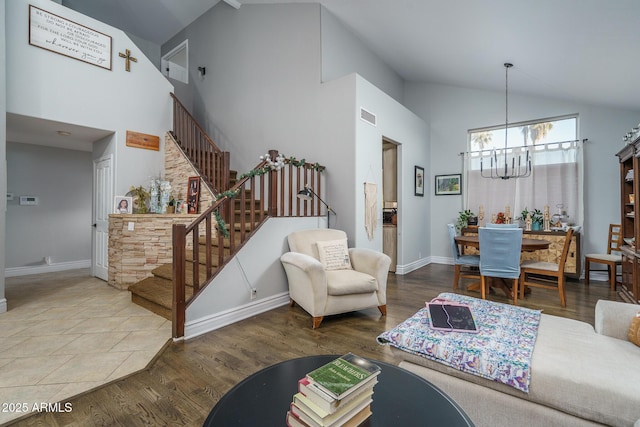 living room with high vaulted ceiling, stairway, wood finished floors, and visible vents