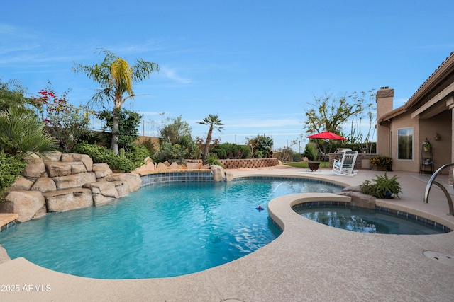 pool featuring a patio area and an in ground hot tub