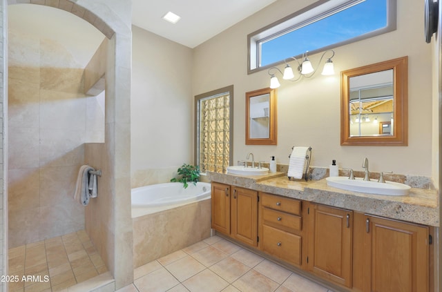 bathroom featuring tile patterned floors, a tile shower, a garden tub, and a sink