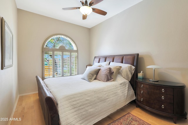 bedroom with baseboards, a ceiling fan, and light wood-style floors