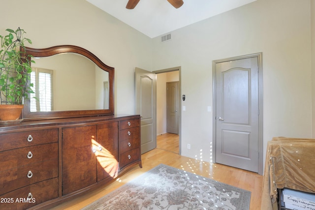 bedroom featuring light wood-style floors, high vaulted ceiling, ceiling fan, and visible vents