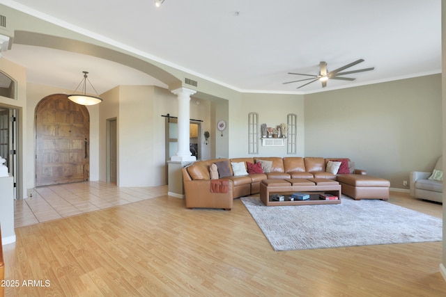 living room featuring visible vents, arched walkways, decorative columns, a ceiling fan, and wood finished floors