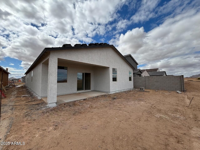 back of property with a patio, fence, and stucco siding