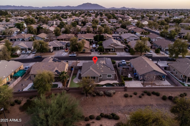 aerial view at dusk featuring a residential view and a mountain view