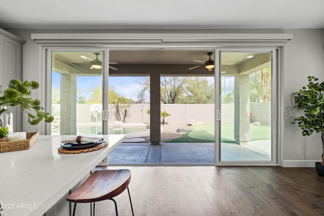 doorway to outside with plenty of natural light, a ceiling fan, and wood finished floors