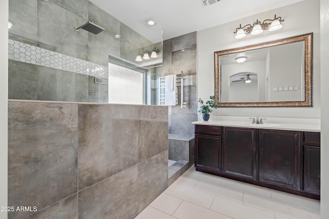 bathroom with visible vents, a ceiling fan, tile patterned floors, walk in shower, and vanity