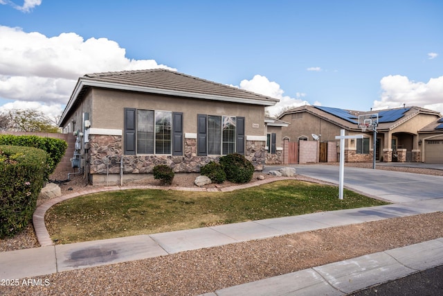 view of front of home featuring fence, stone siding, driveway, a gate, and stucco siding