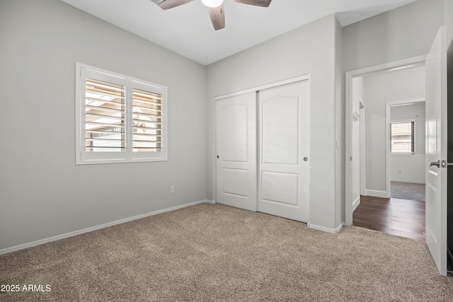 unfurnished bedroom featuring carpet floors, ceiling fan, baseboards, and a closet