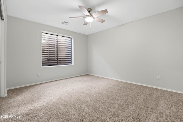 empty room with ceiling fan, carpet, visible vents, and baseboards