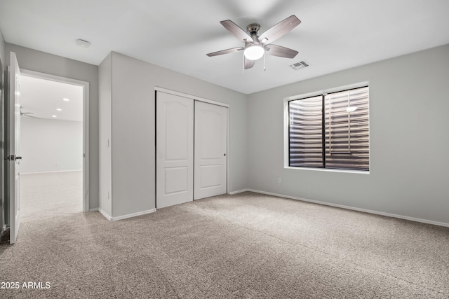 unfurnished bedroom featuring ceiling fan, carpet flooring, visible vents, baseboards, and a closet