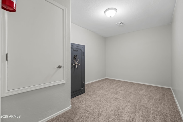 unfurnished room featuring carpet floors, baseboards, visible vents, and a textured ceiling