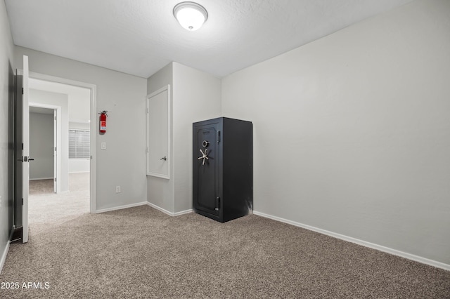 unfurnished bedroom with carpet flooring, a textured ceiling, and baseboards