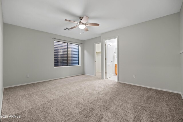 carpeted empty room with a ceiling fan, visible vents, and baseboards