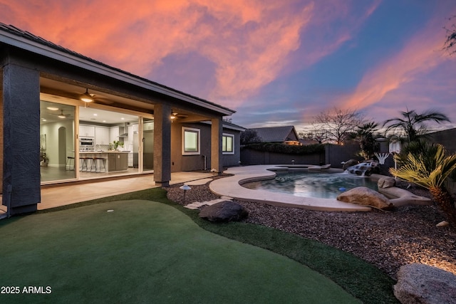 yard at dusk featuring a fenced in pool, a fenced backyard, and a patio