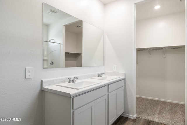 18362 W Hackamore Dr, Wittmann, AZ 85361 - bathroom featuring double vanity, wood finished floors, and a spacious closet