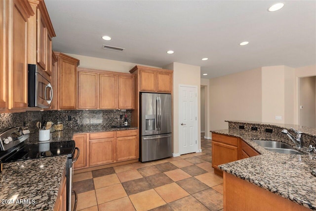 kitchen featuring sink, stainless steel appliances, dark stone countertops, decorative backsplash, and light tile patterned floors