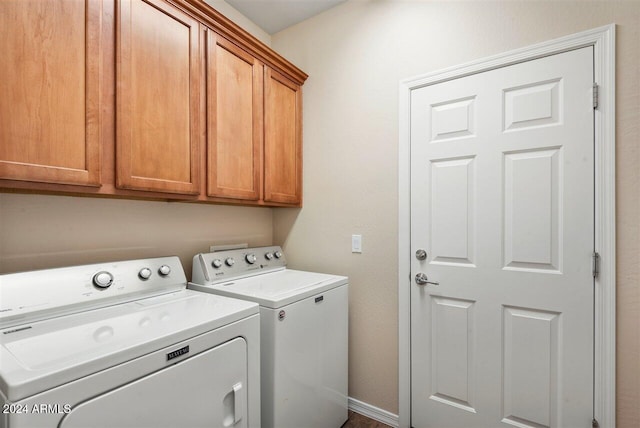 clothes washing area featuring washing machine and dryer and cabinets