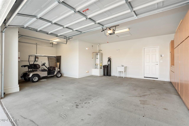 garage with gas water heater, a garage door opener, and sink